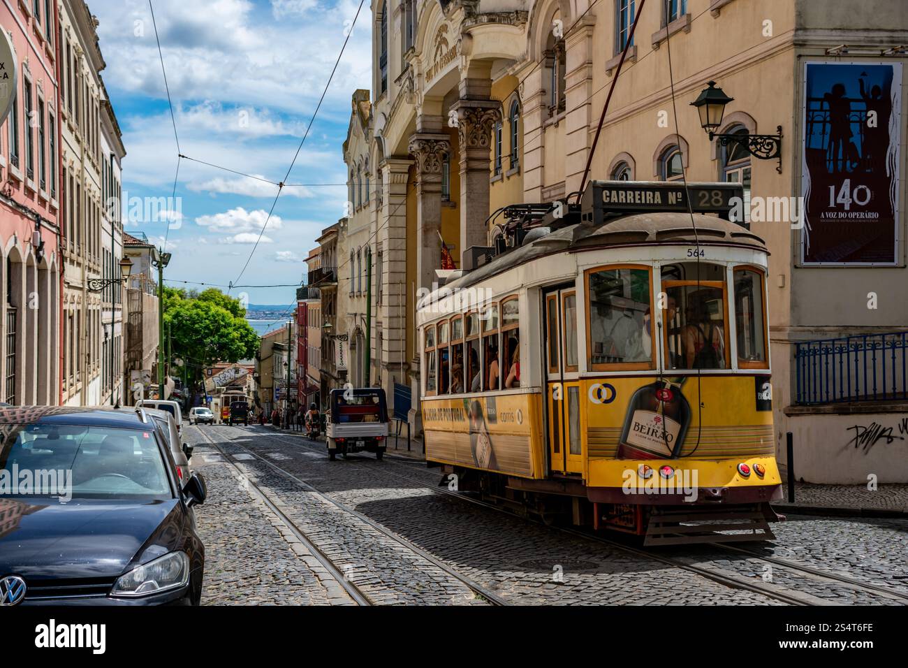 On a hill to Graça in Lisbon, the iconic Tram 28 passes through charming streets, offering a glimpse into the city's history and vibrant culture. Stock Photo