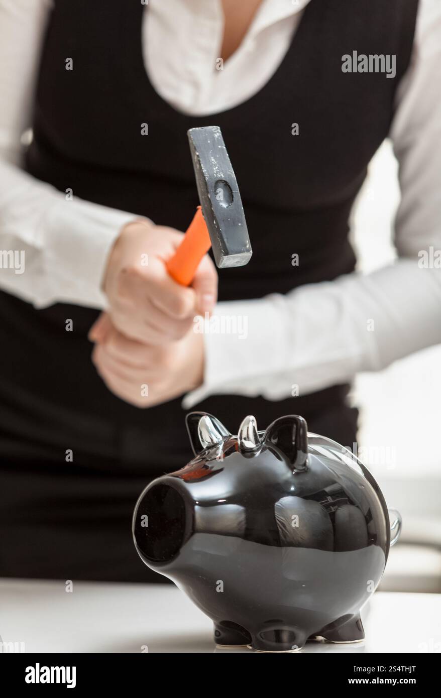 Closeup photo of woman smashing black piggy bank with hammer Stock ...