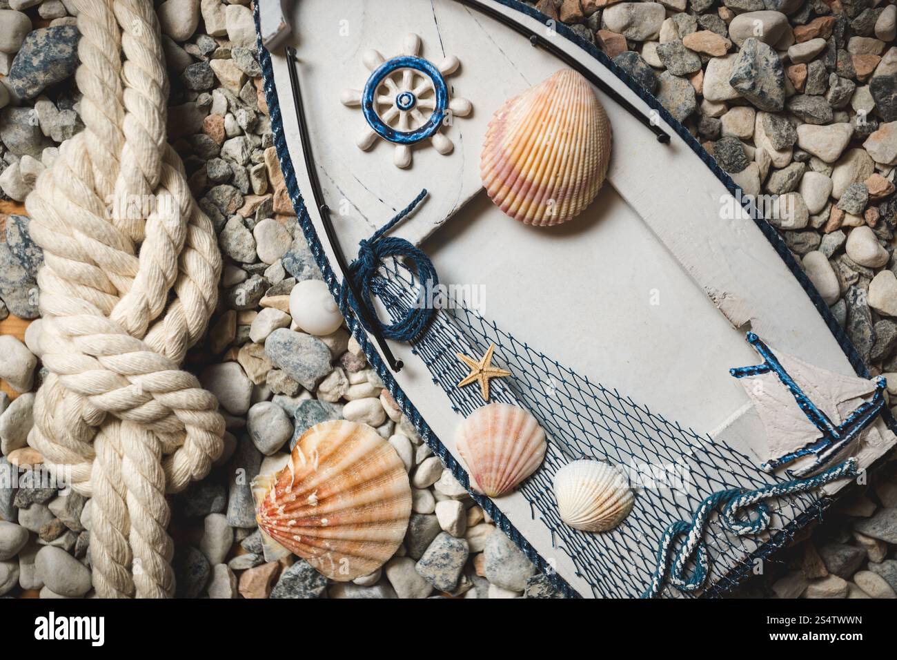 Shell Ropes Wooden frame decorated by shells and ropes lying on stones at shore ...