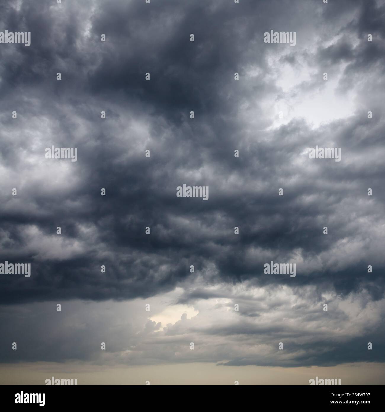 heavy low storm clouds in evening spring sky Stock Photo