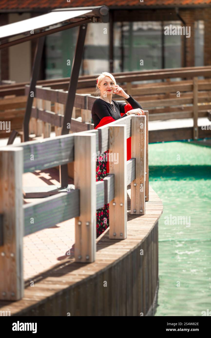 Beautiful blonde woman posing on bridge over canal at sunny day Stock ...