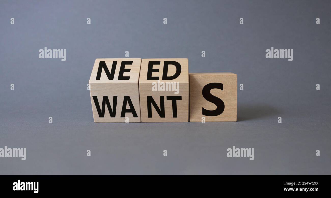 Needs and Wants symbol. Wooden cubes with words Wants and Needs ...
