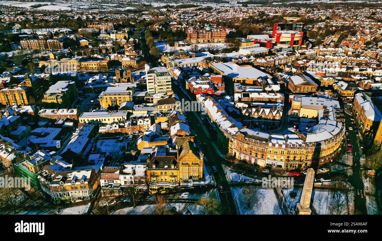 Aerial view of a snow-covered town, featuring a central street lined ...