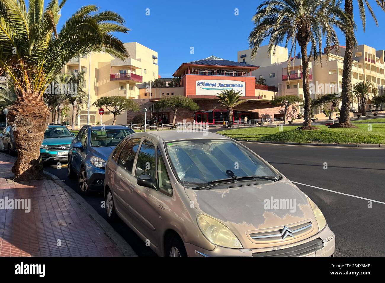 Cars parked across the street from the Hotel Best Jacaranda in Costa Adeje, Tenerife, Canary Islands, Spain. 11th January 2025. - Smartphone Captured Stock Image
