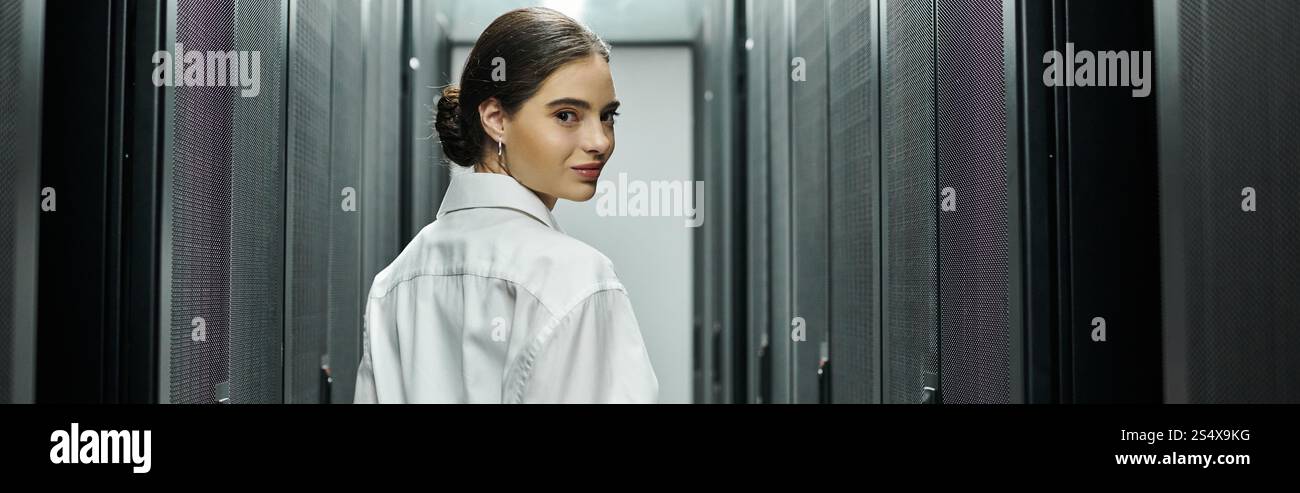 IT specialist in a white shirt skilfully managing servers in a modern data center, banner Stock Photo
