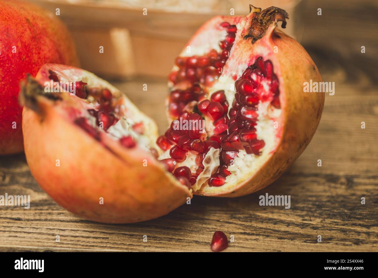 Macro shot of two pomegranate halves on wooden desk Stock Photo