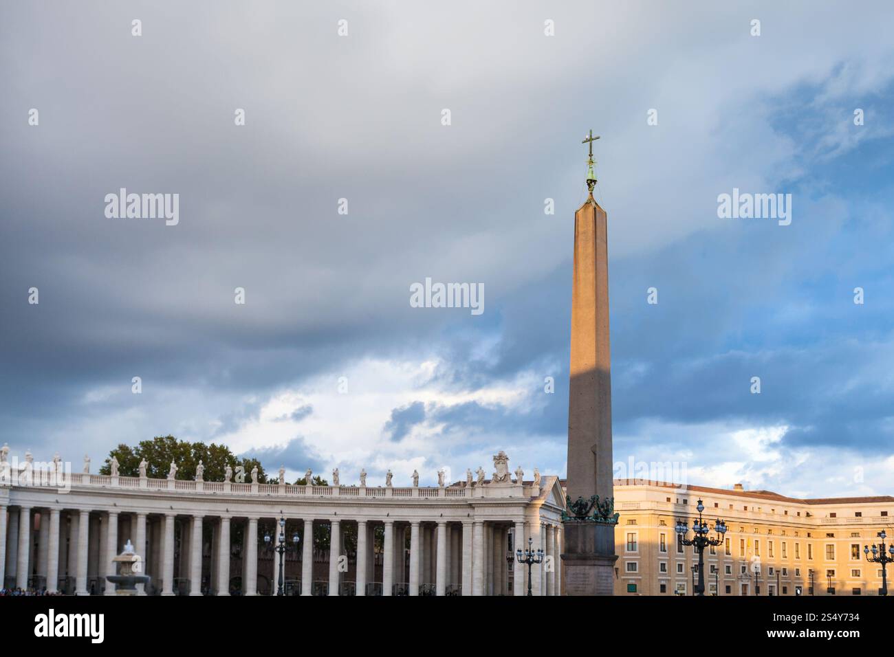 travel to Italy - obelisk with cross and Bernini's colonnade on Saint Peter's Square (Piazza San Pietro) in Vatican city in evening Stock Photo