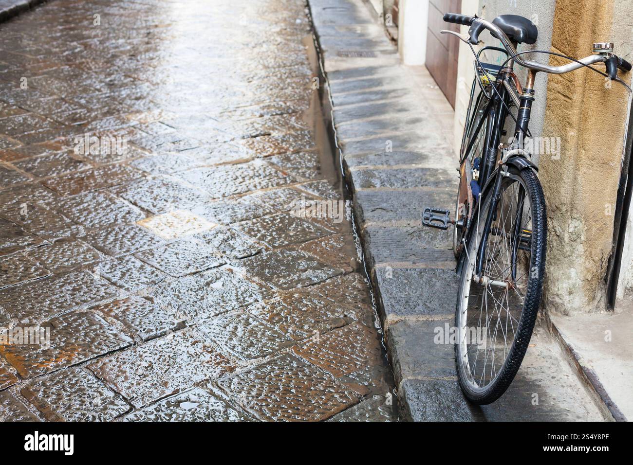 travel to Italy - bicycle on wet street in Florence city in autumn rain Stock Photo