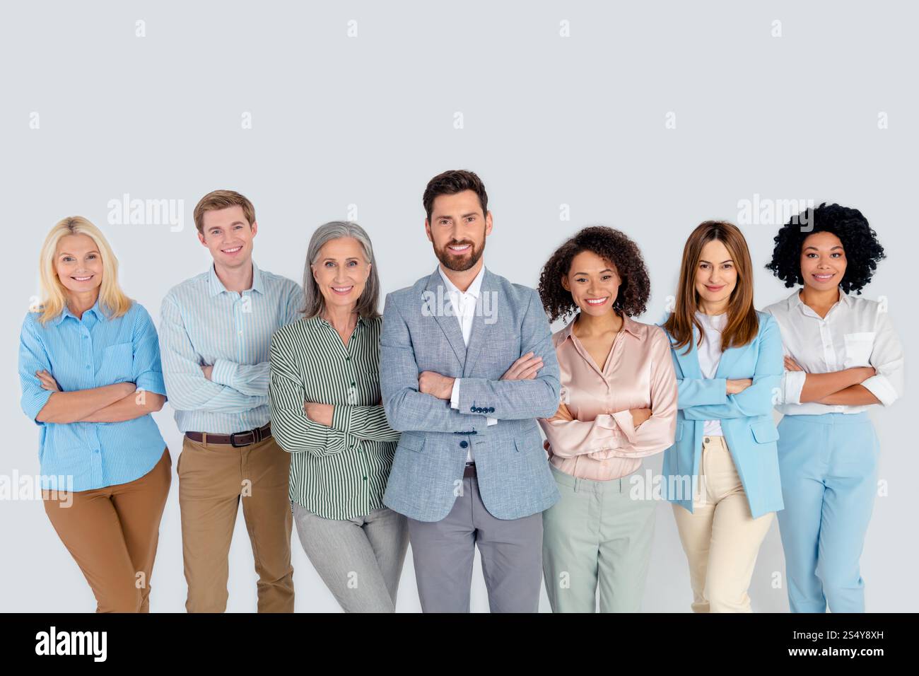 Diverse group of professionals standing together on a grey background ...