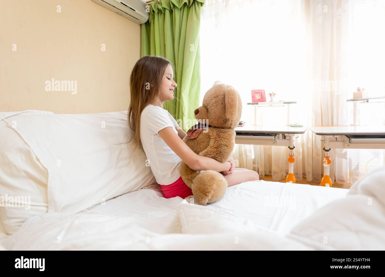 Little cute girl sitting hugging her teddy bear Stock Photo - Alamy