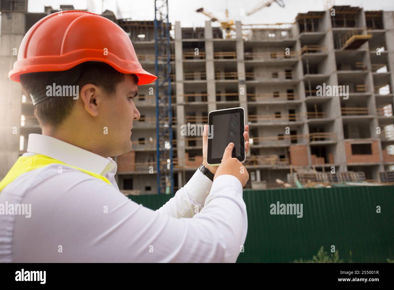 Young construction engineer using digital tablet on building site Stock Photo