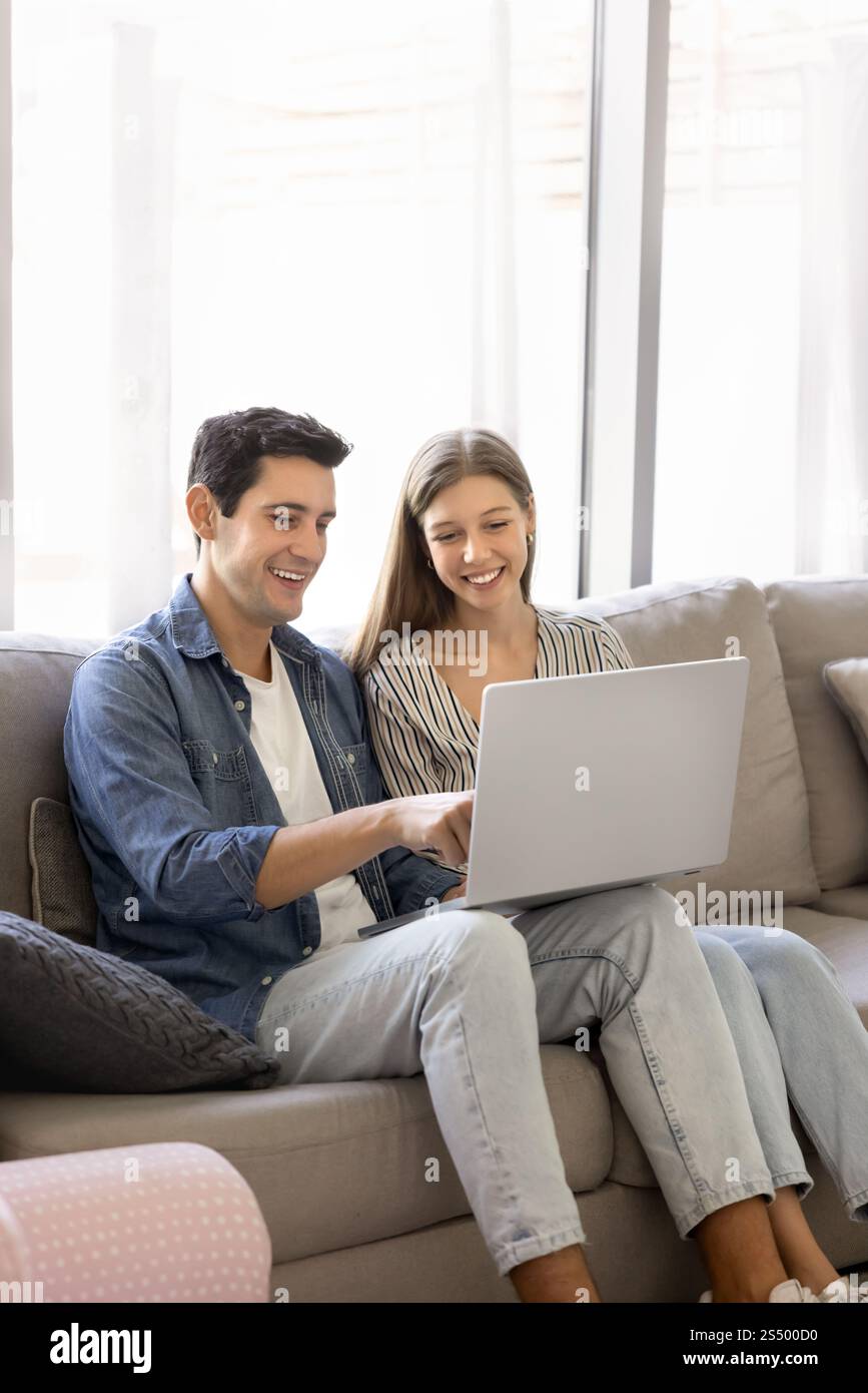 Positive young Hispanic couple using online application Stock Photo