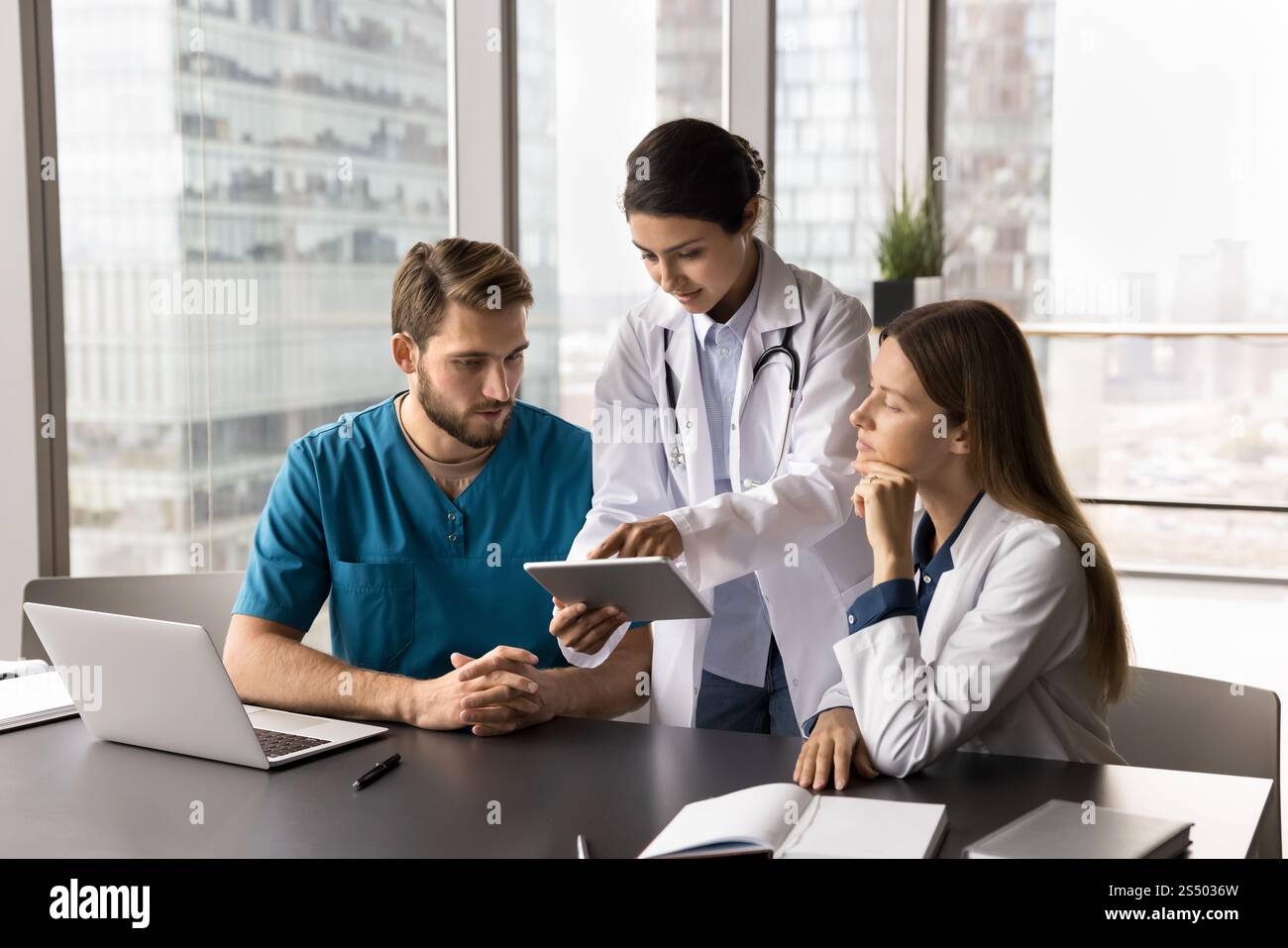 Three multinational doctors working together using digital tablet Stock Photo