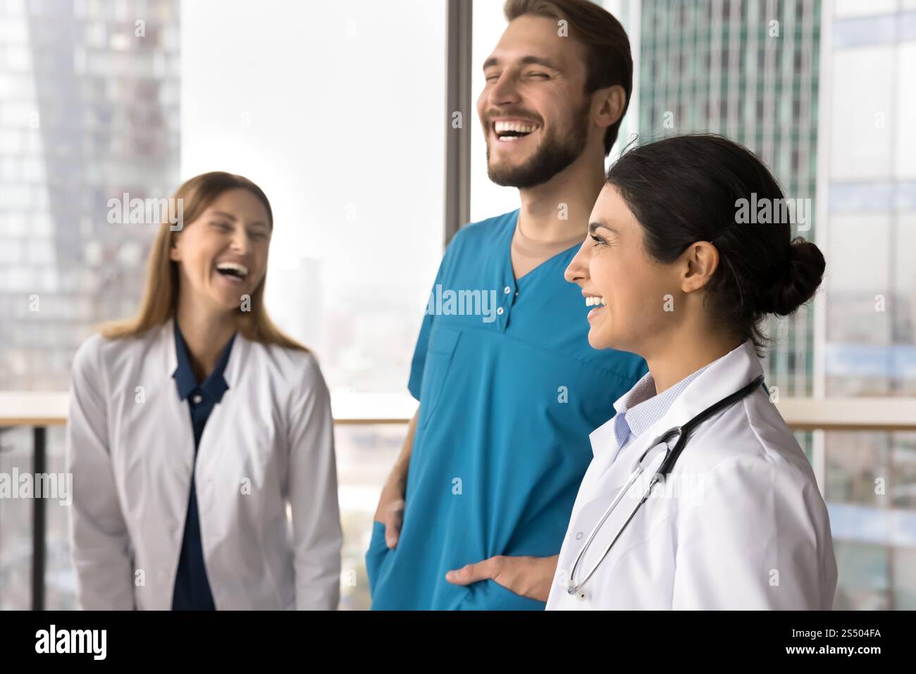 Three multiethnic doctors in uniforms, laughing, sharing lighthearted moments Stock Photo