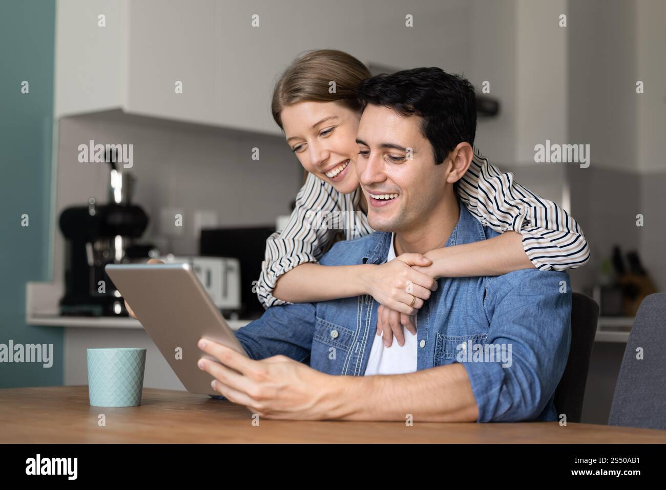 Cheerful attractive Hispanic couple using tablet computer Stock Photo