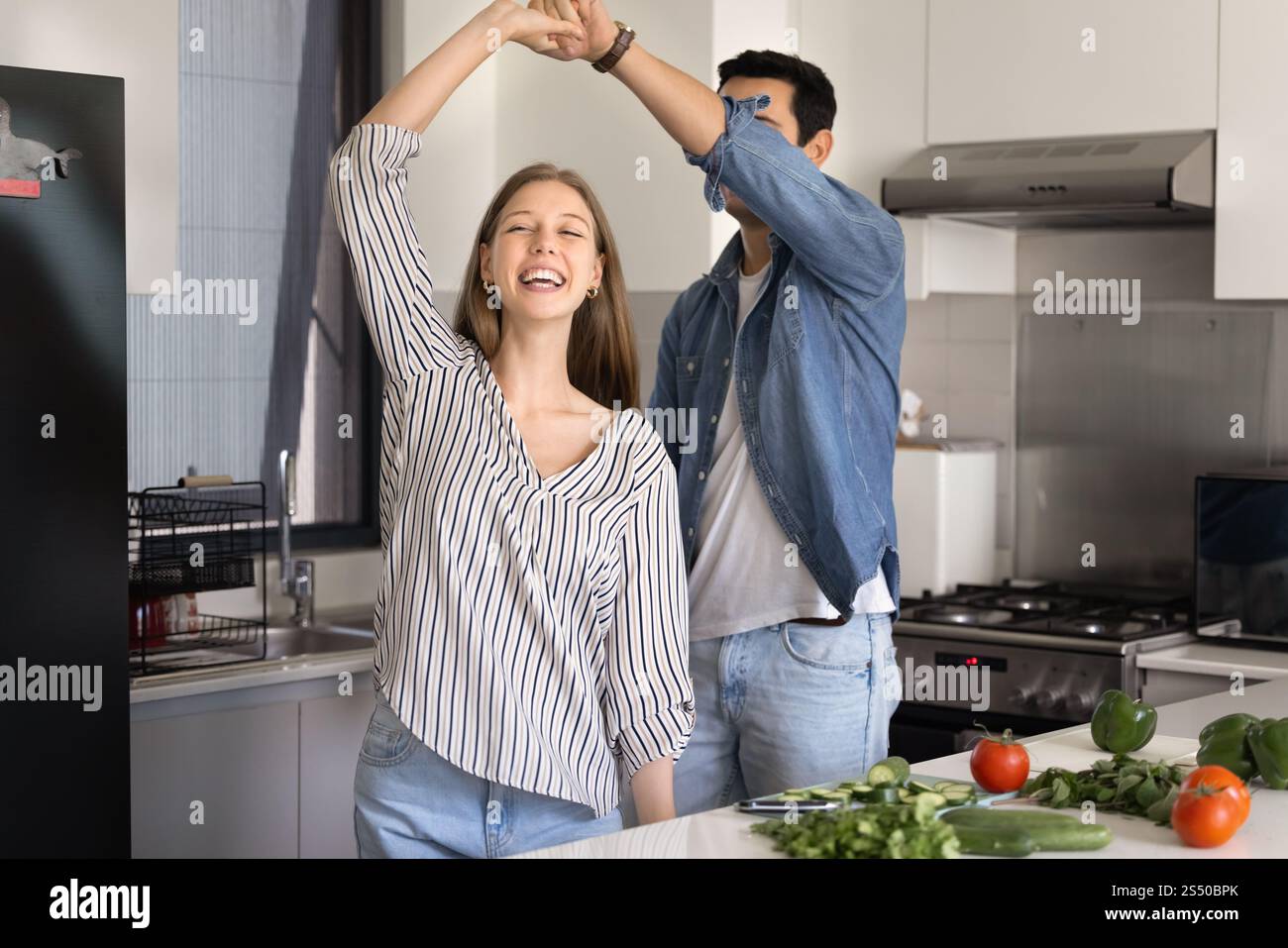 Cheerful young couple cooking and having fun at home Stock Photo