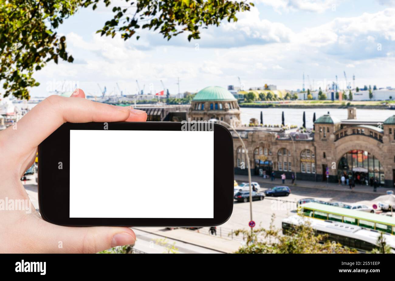 travel concept - tourist photographs St Pauli Landungsbrucken (Sankt Pauli Piers) landing place in Port of Hamburg in september on smartphone with cut Stock Photo