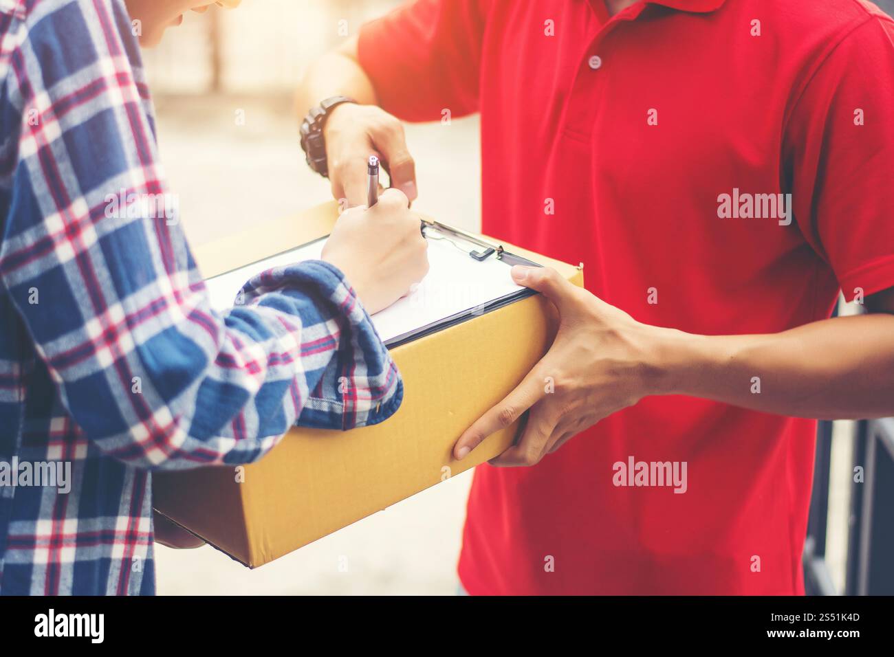 Young man Delivering Package to customer at home. Delivery Stock Photo