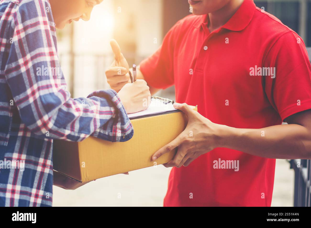 Young man Delivering Package to customer at home. Delivery Stock Photo