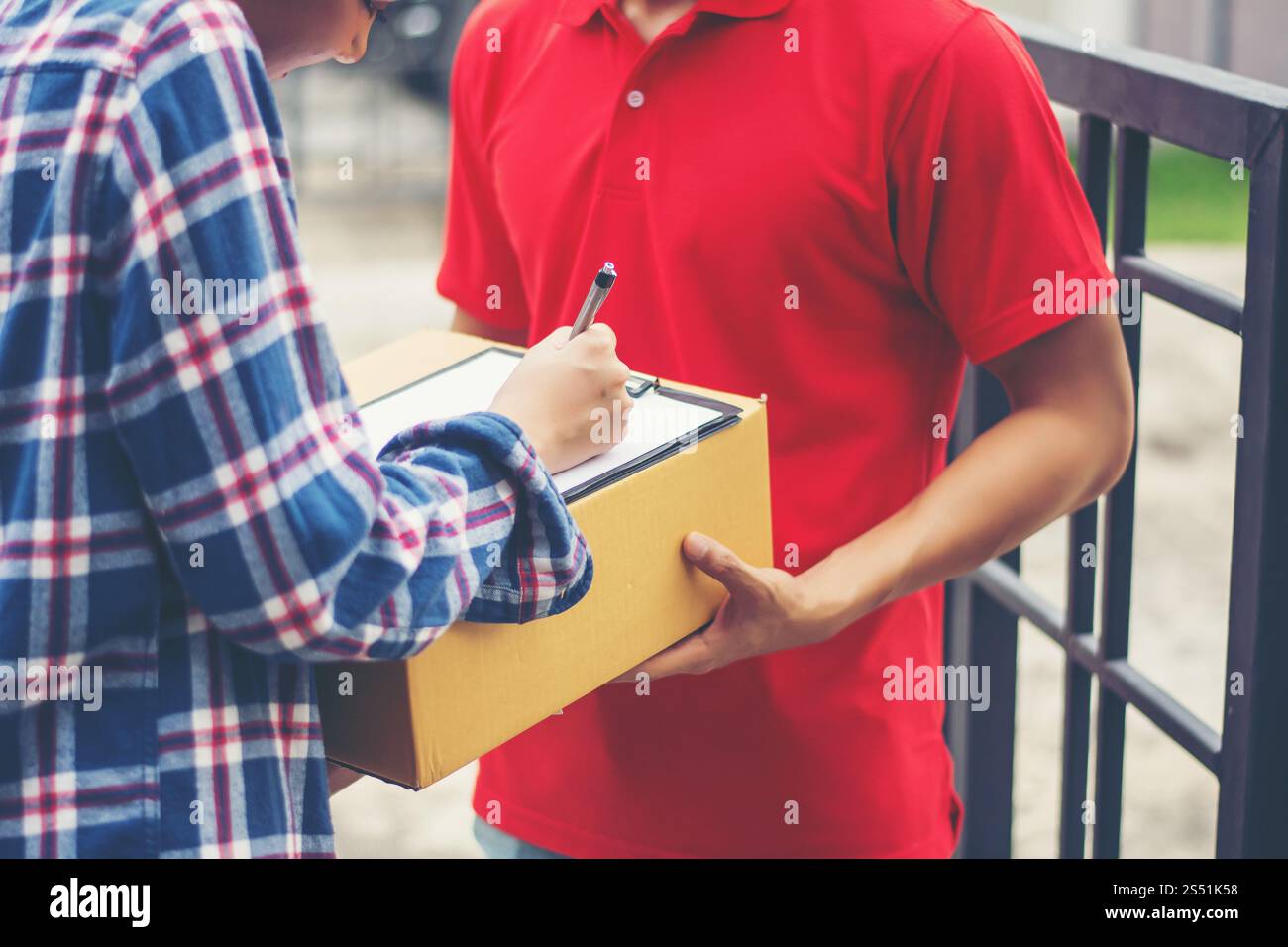 Young man Delivering Package to customer at home. Delivery Stock Photo