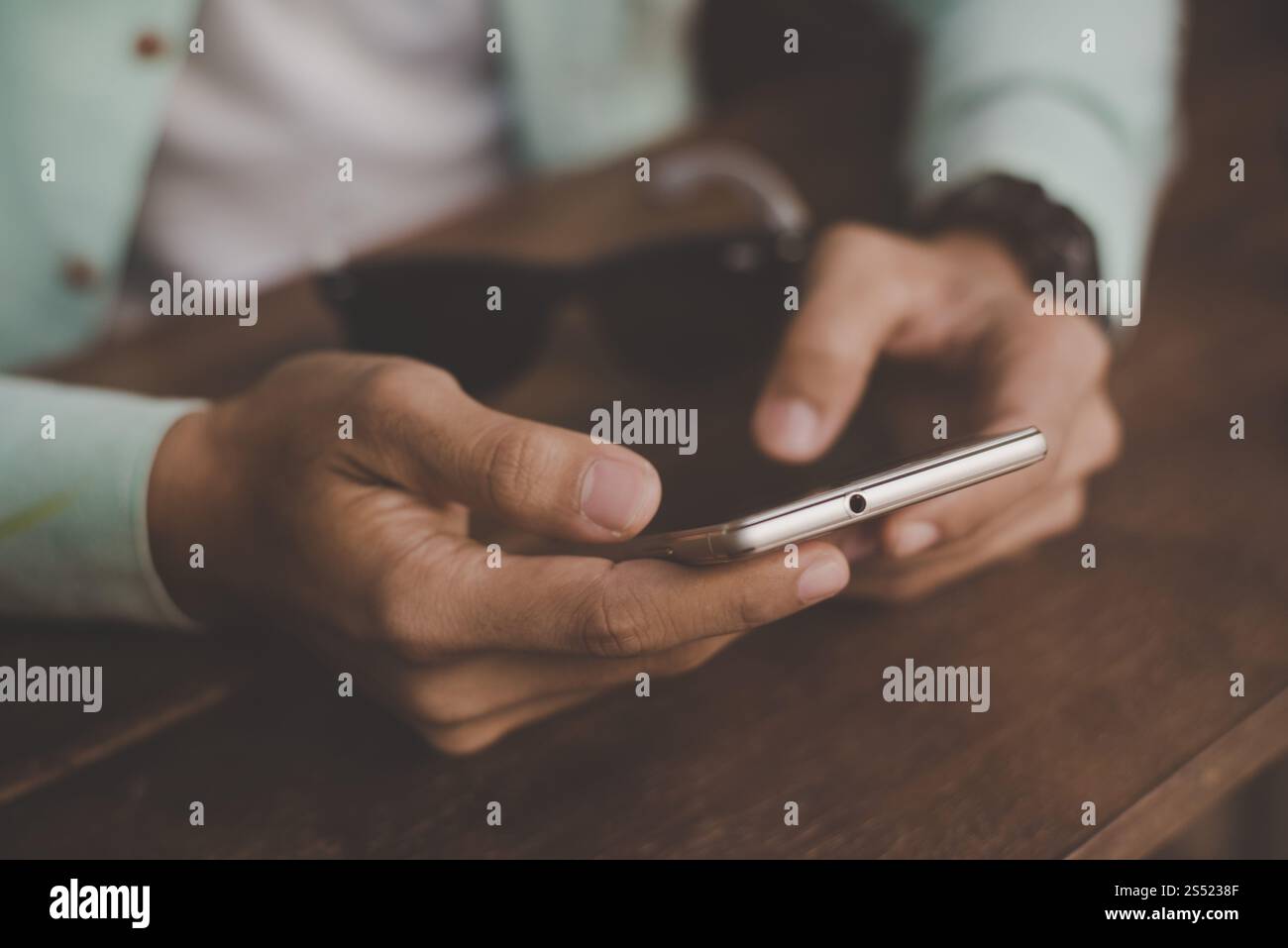 Young hipster guy texting with his mobile phone at the bar. Stock Photo