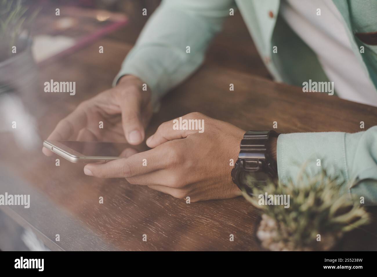 Young hipster guy texting with his mobile phone at the bar. Stock Photo