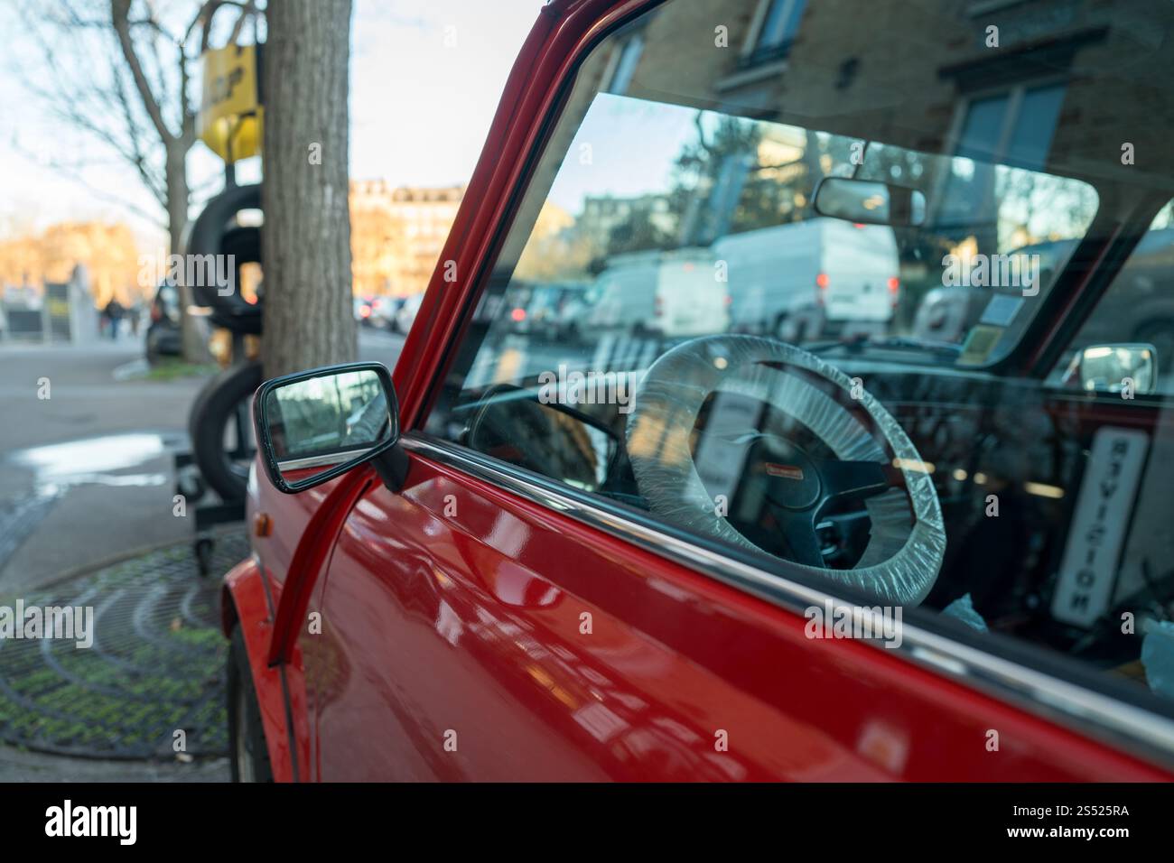 Classic red car parked by a bustling city street during golden hour ...