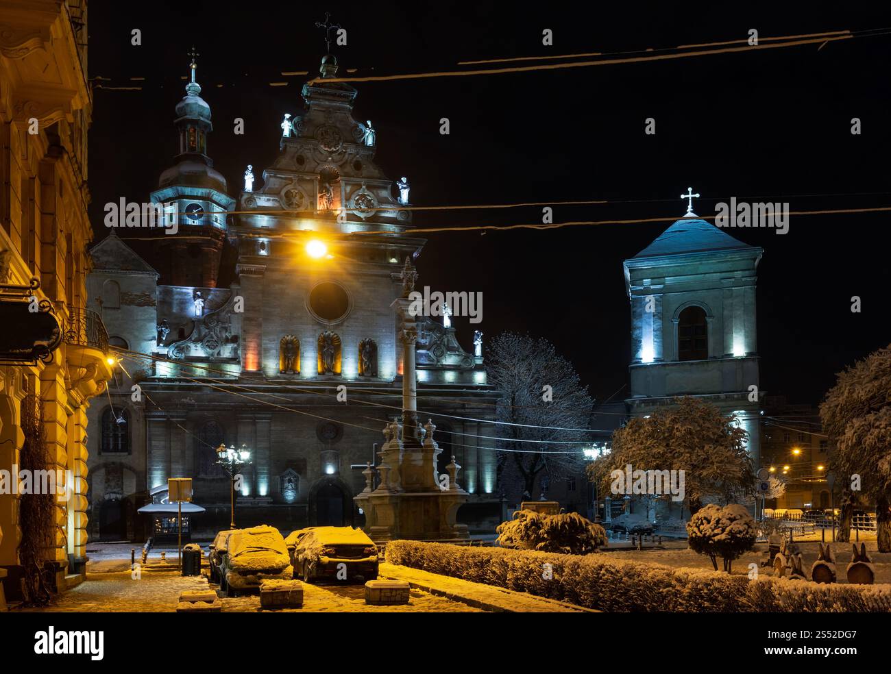 Night winter Lviv city (Ukraine) illuminated cityscape. Bernardine Church and monastery (church of St. Andrew) top, built in17th century. And Stock Photo