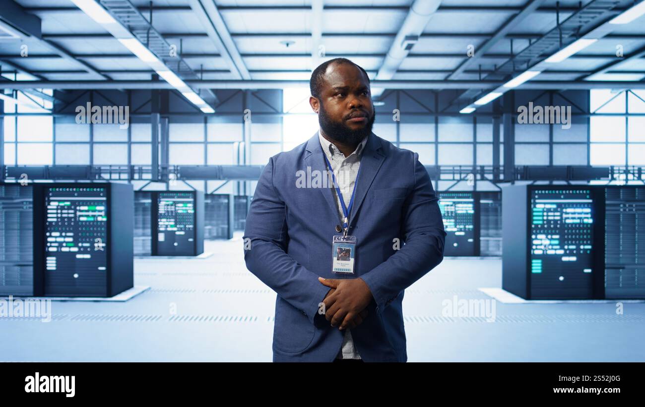 IT expert managing data center with advanced technology, ensuring cybersecurity and efficient network management. Admin in server room maintaining and optimizing data center infrastructure, camera B Stock Photo