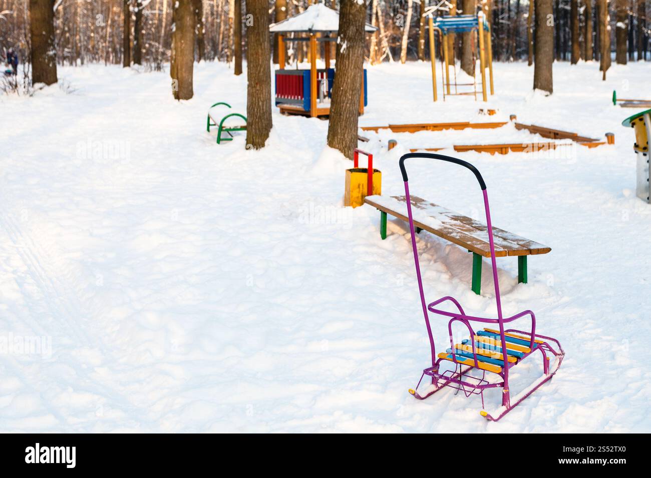 snow-covered playground in urban park in winter twilight. in 