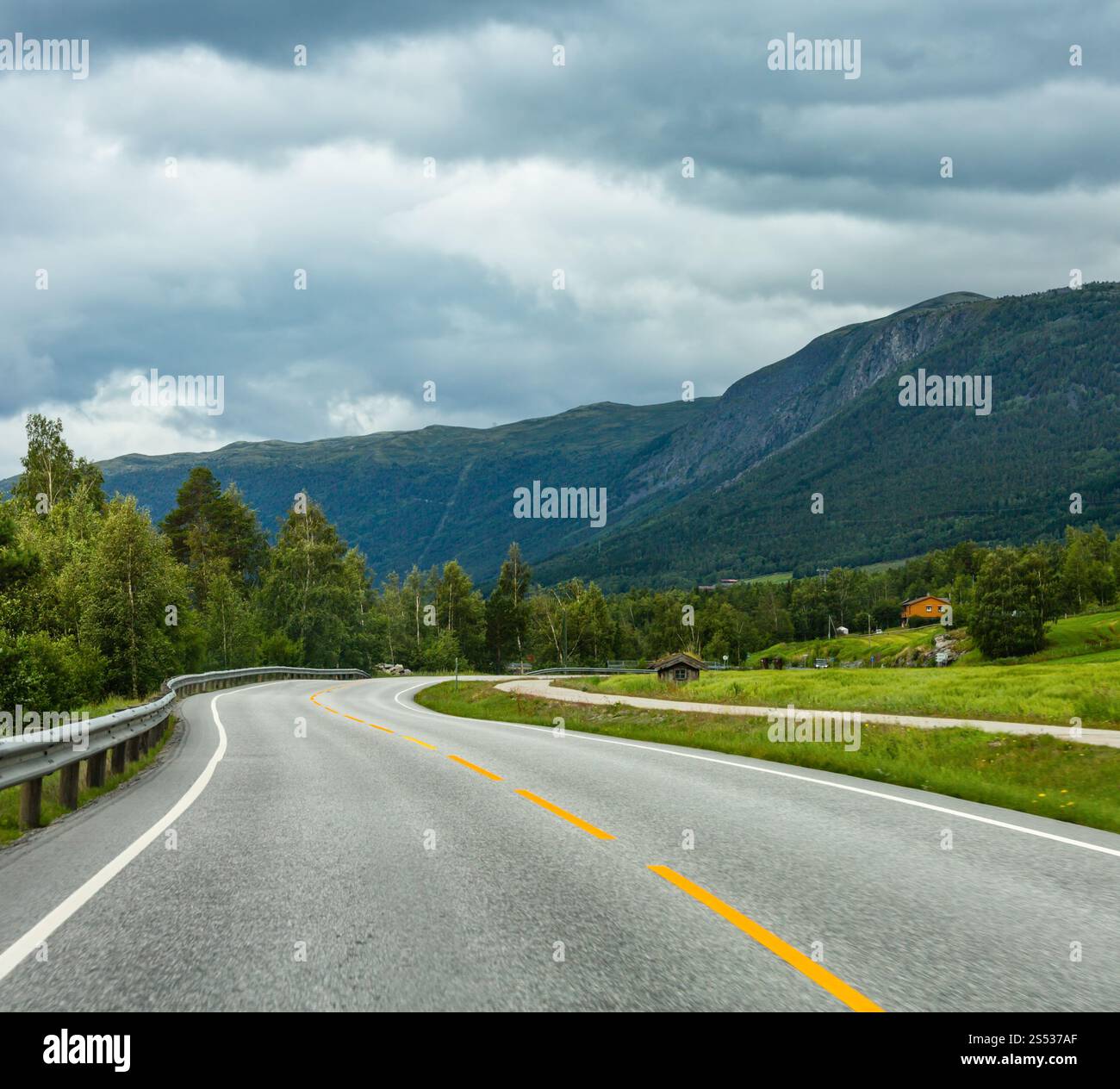 Summer cloudy mountain landscape with serpentine secondary road, Norway Stock Photo