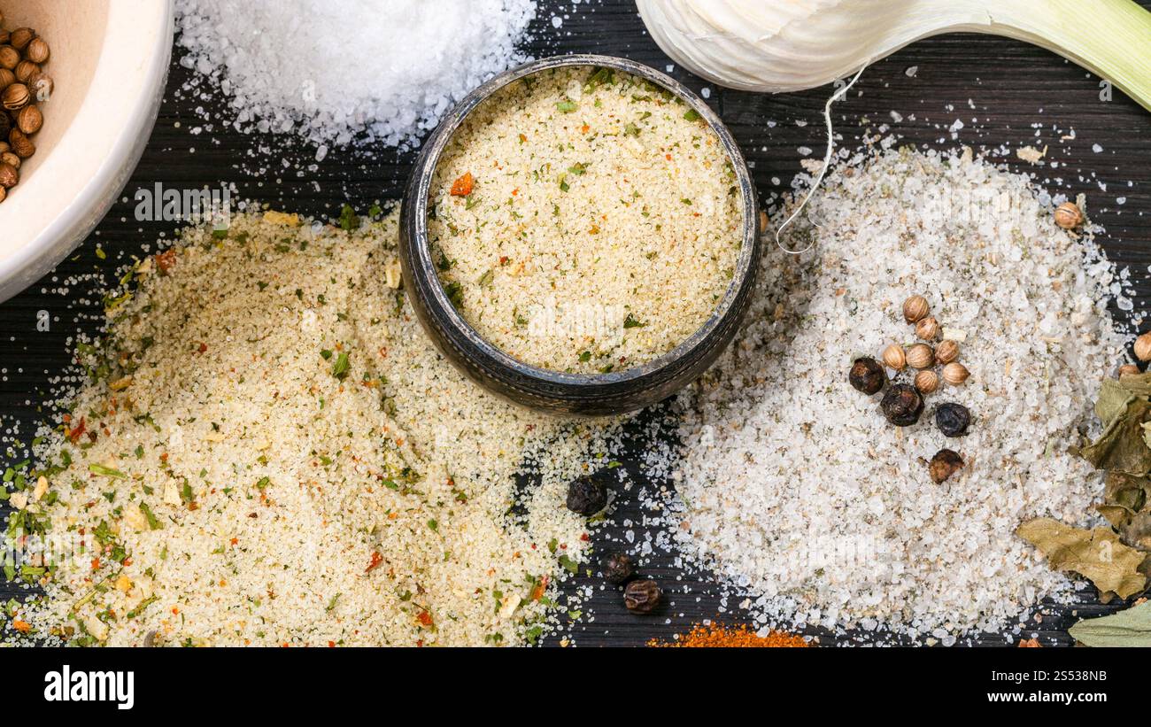 top view of salt cellar and various Seasoned Salts with ingredients on dark wooden table Stock Photo