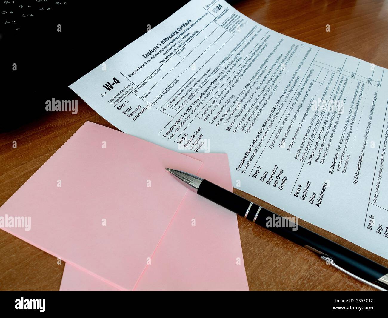 View of tax form W-4 with pen notebook on office desk. Paperwork ...