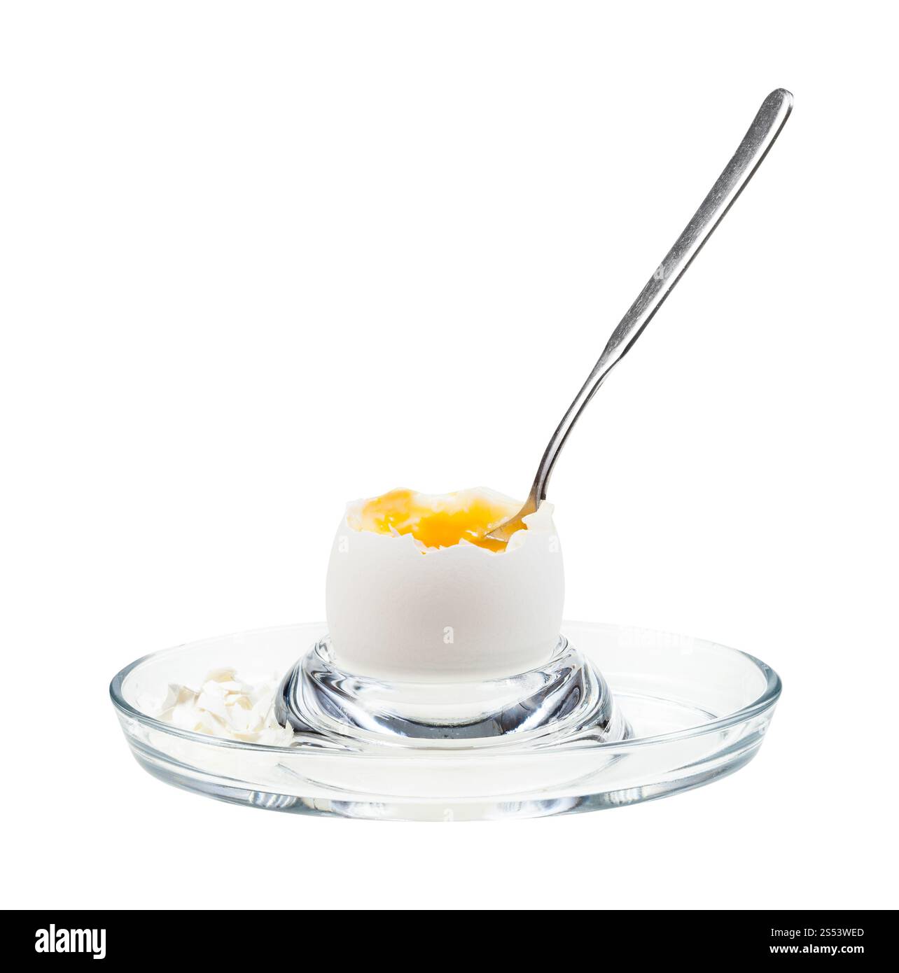 side view of open soft-boiled white egg with spoon in glass egg cup ...