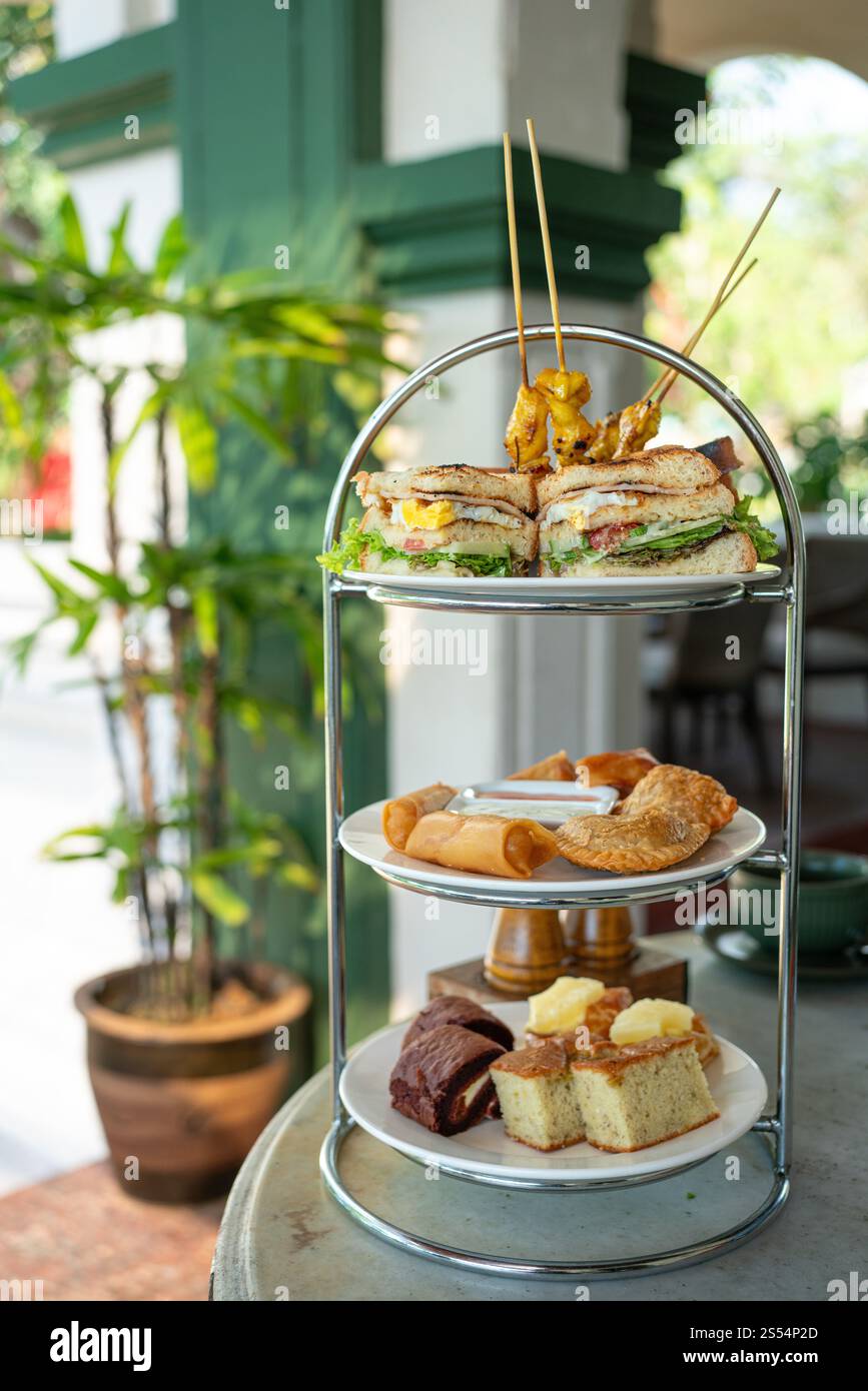 Afternoon tea stand with savoury and sweet treats, served in a ...