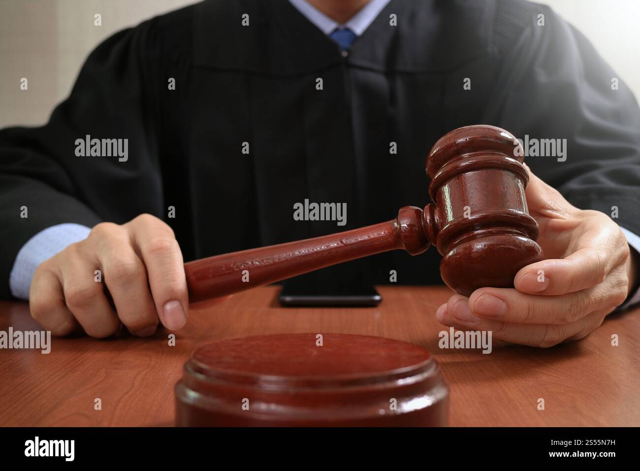 Justice Tablet justice and law concept.Male judge in a courtroom striking the gavel ...
