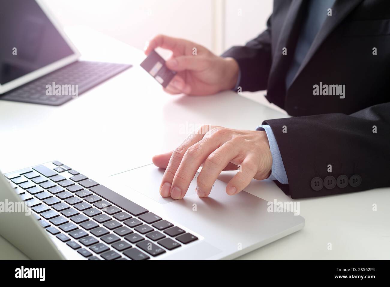 businessman making credit card purchase online with laptop computer on modern desk Stock Photo