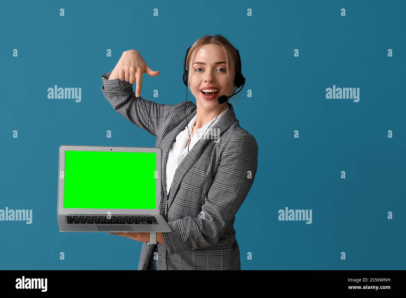 Female technical support agent holding laptop with green screen on blue ...
