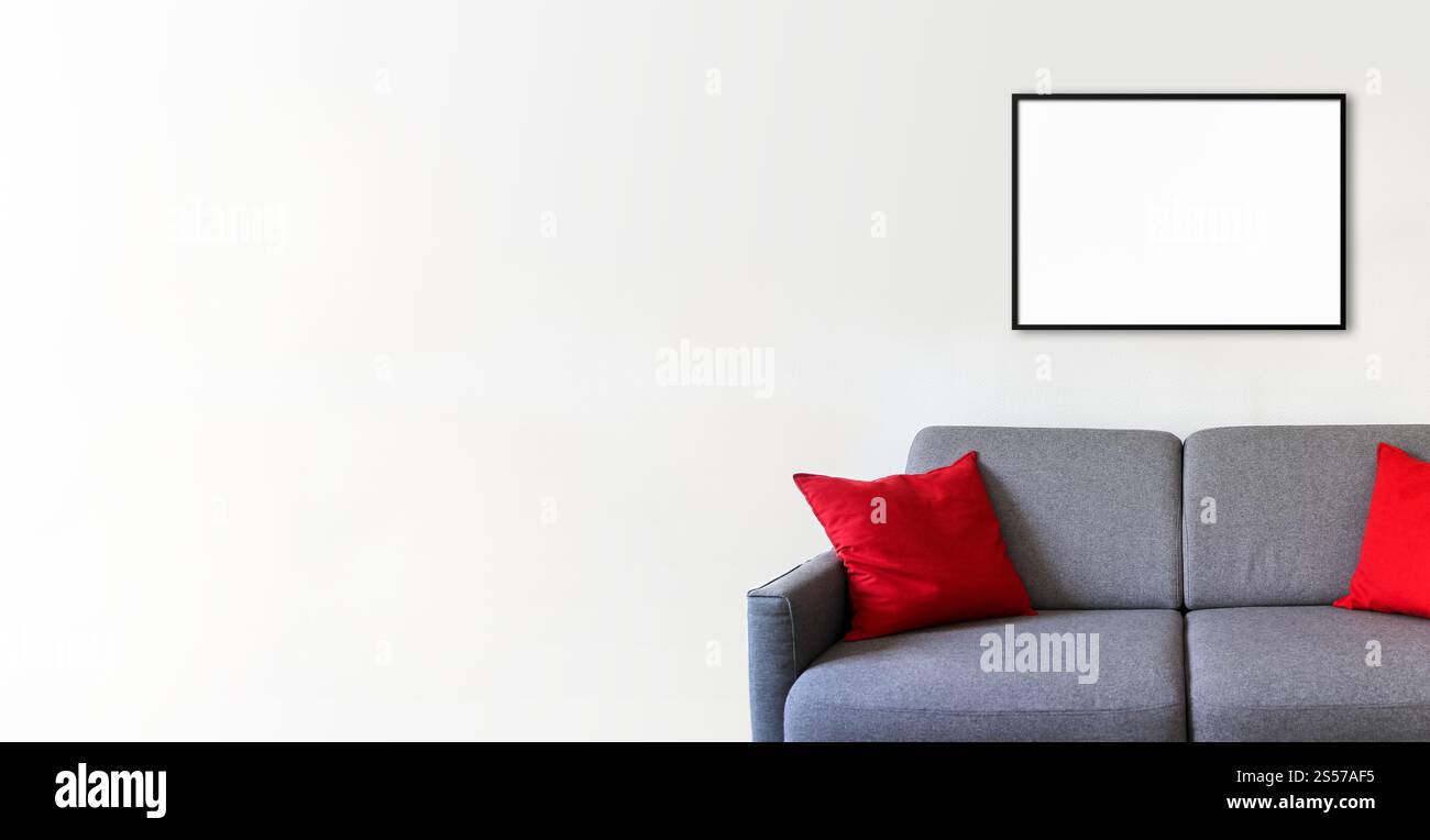 Empty picture frame on a white wall above a sofa. Minimalist interior ...