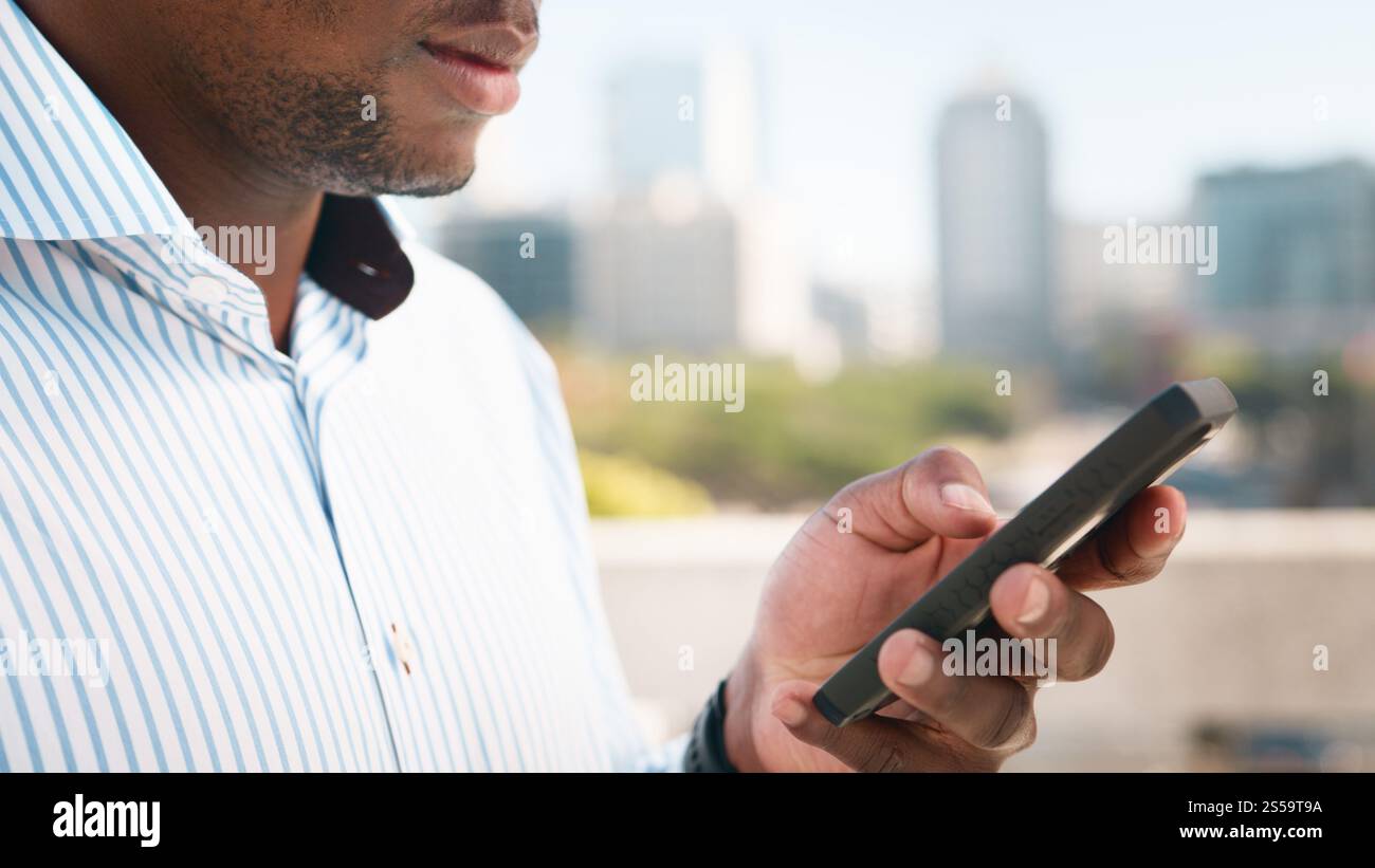 Professional Individual Engages with Smartphone Outdoors in Urban Setting Stock Photo