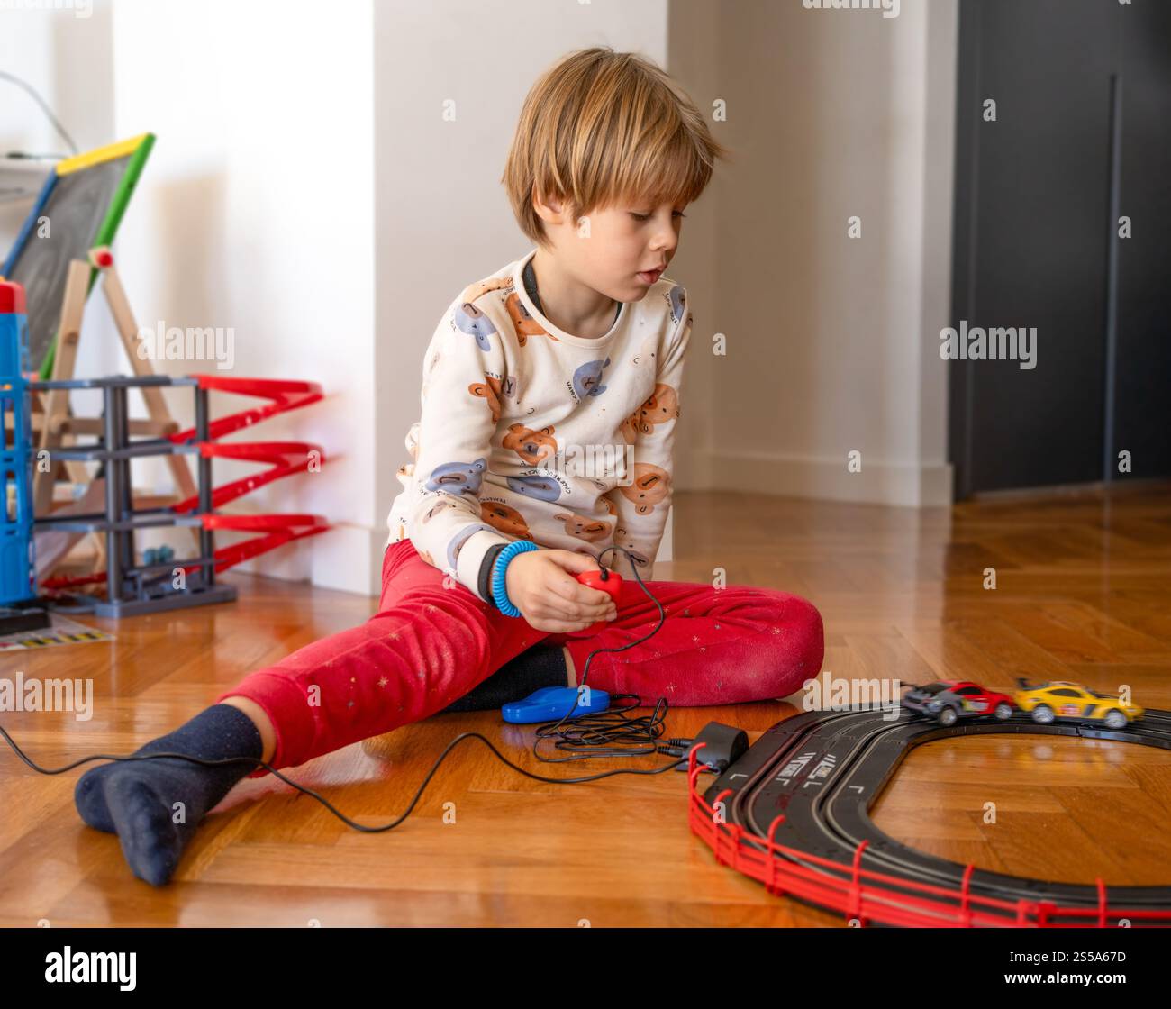 Child boy sitting on floor at home playing with toy cars Stock Photo ...