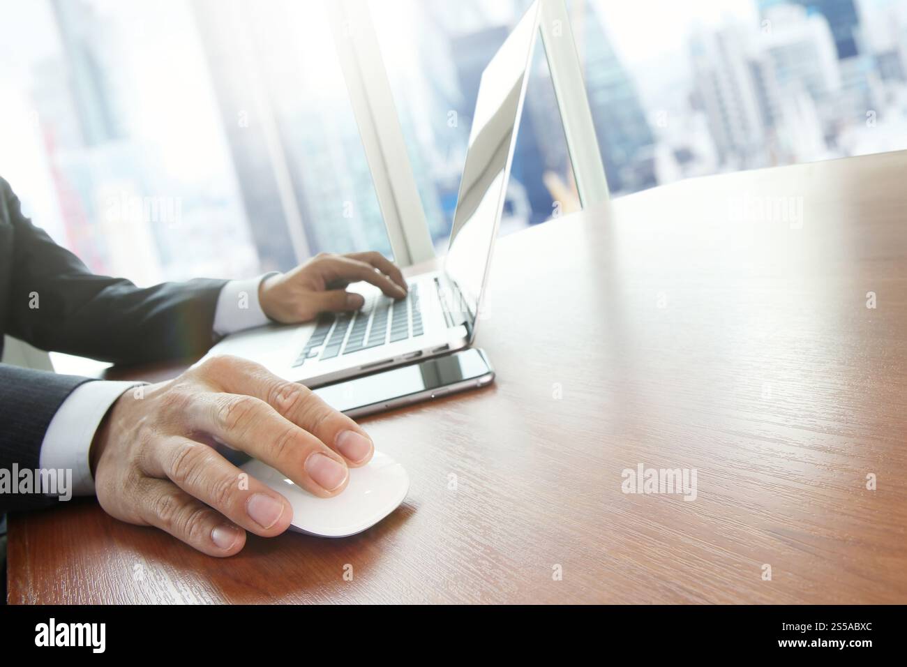 Close up of male hands on mouse and over black keyboard of laptop ...