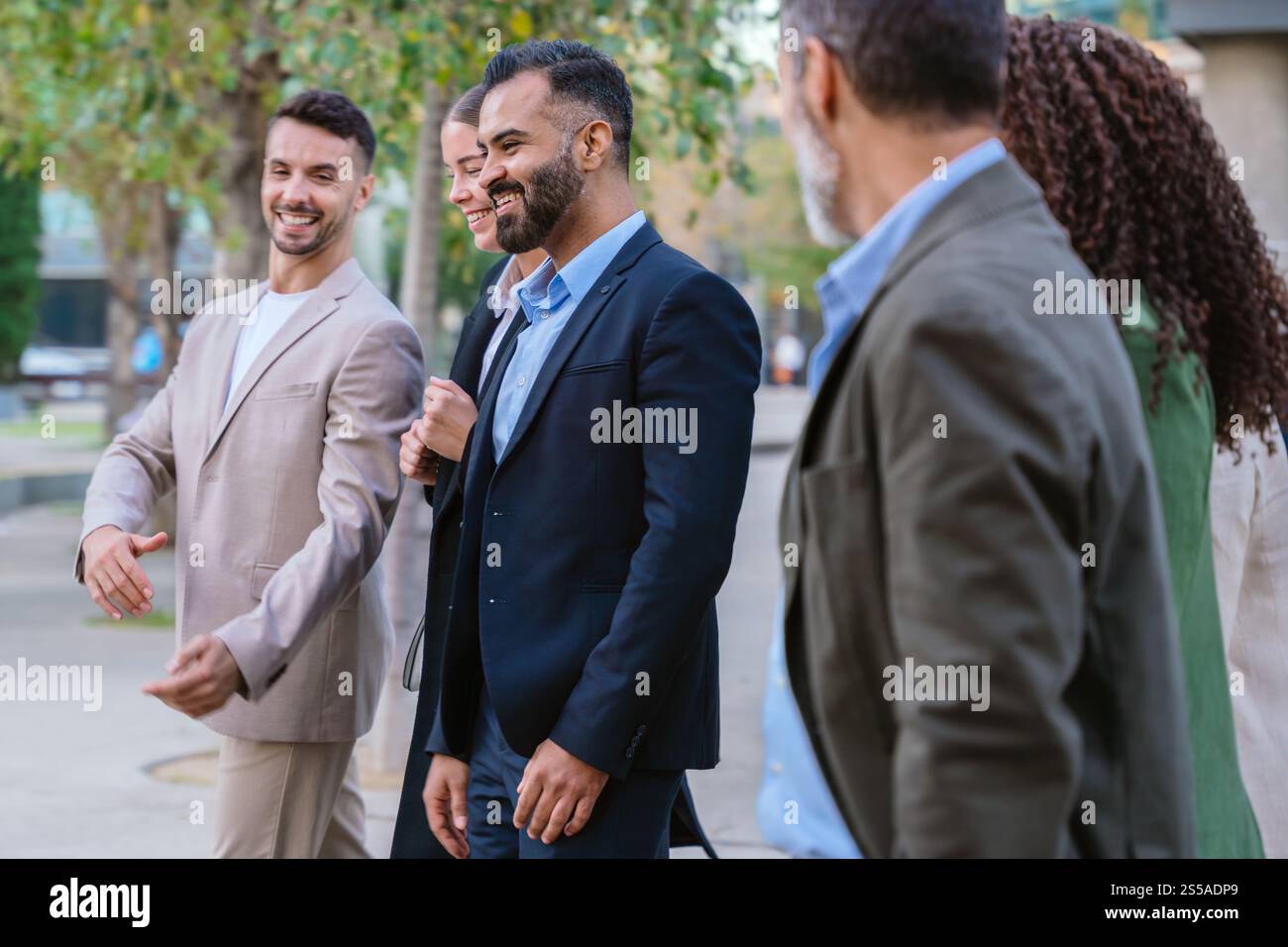 Group of Business Professionals Walking and Talking Outdoors Stock Photo