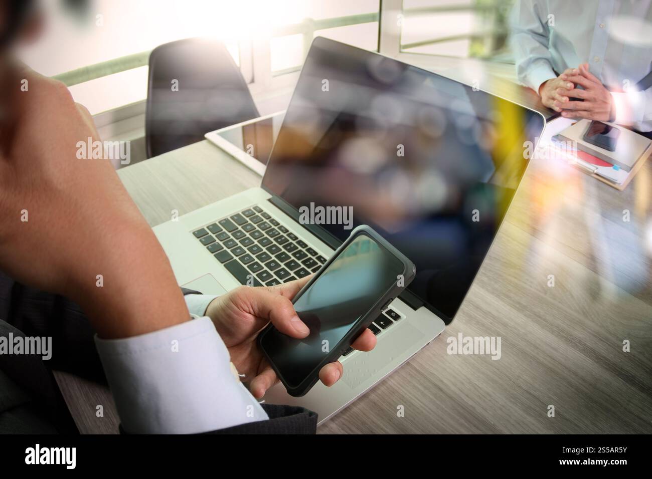 Businessman making presentation using smart phone with his colleagues ...