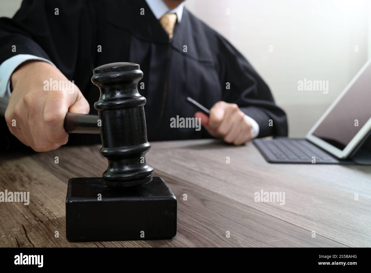 Justice Tablet justice and law concept.Male judge in a courtroom striking the gavel ...