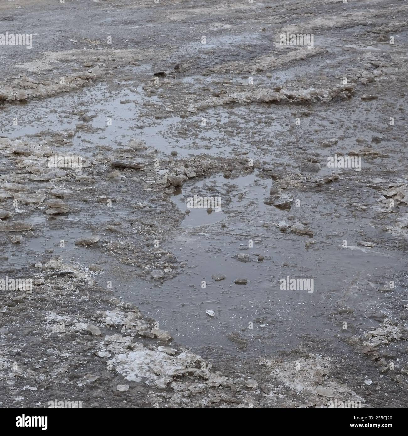 Freezing Roard Condition Damaged asphalt road with potholes caused by freezing and thawing ...