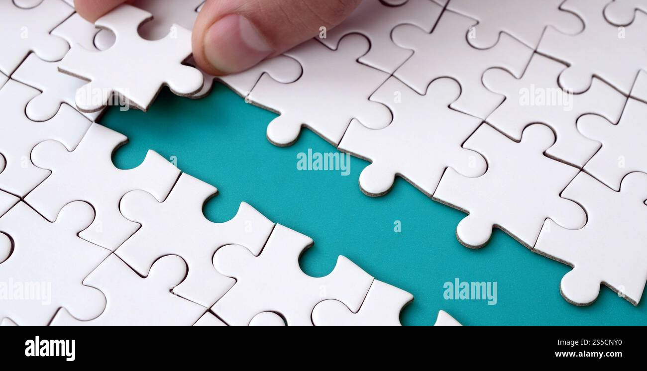 The human hand paves the way to the surface of the jigsaw puzzle The human hand paves the way to the surface of the jigsaw puzzle