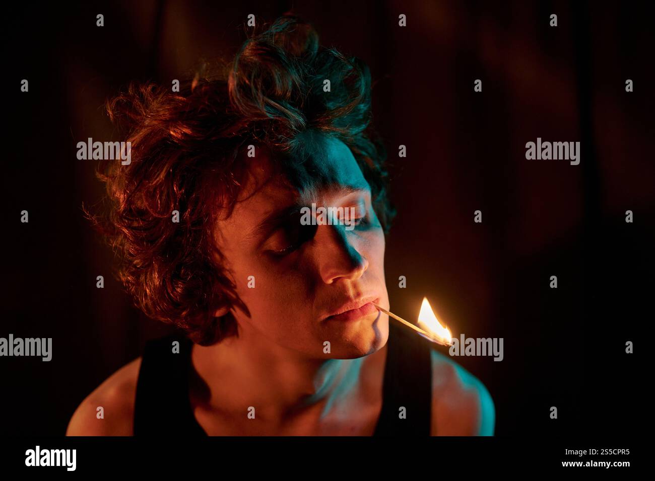 cigarette in dark room Young Man with Cigarette in the Dark Room Stock Photo