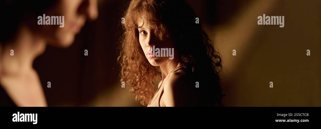 Website banner with curly haired woman looking at her unrecognizable boyfriend Stock Photo