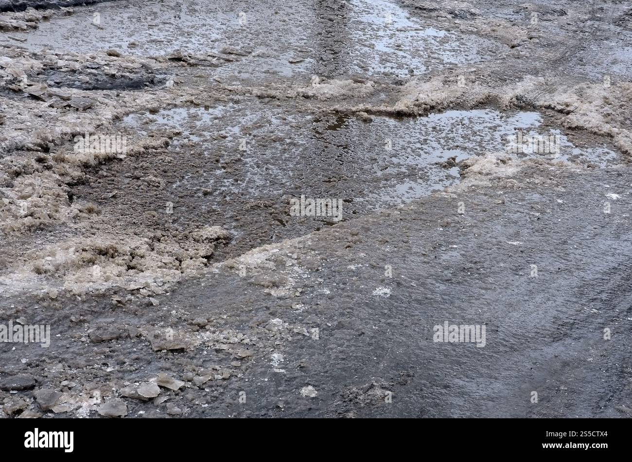 Freezing Roard Condition Damaged asphalt road with potholes caused by freezing and thawing ...